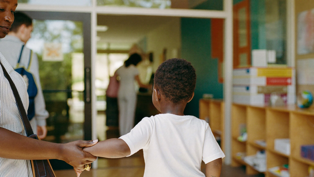 Parent at a bright New England daycare with insurance paperwork, health insurance and child care in a child support order